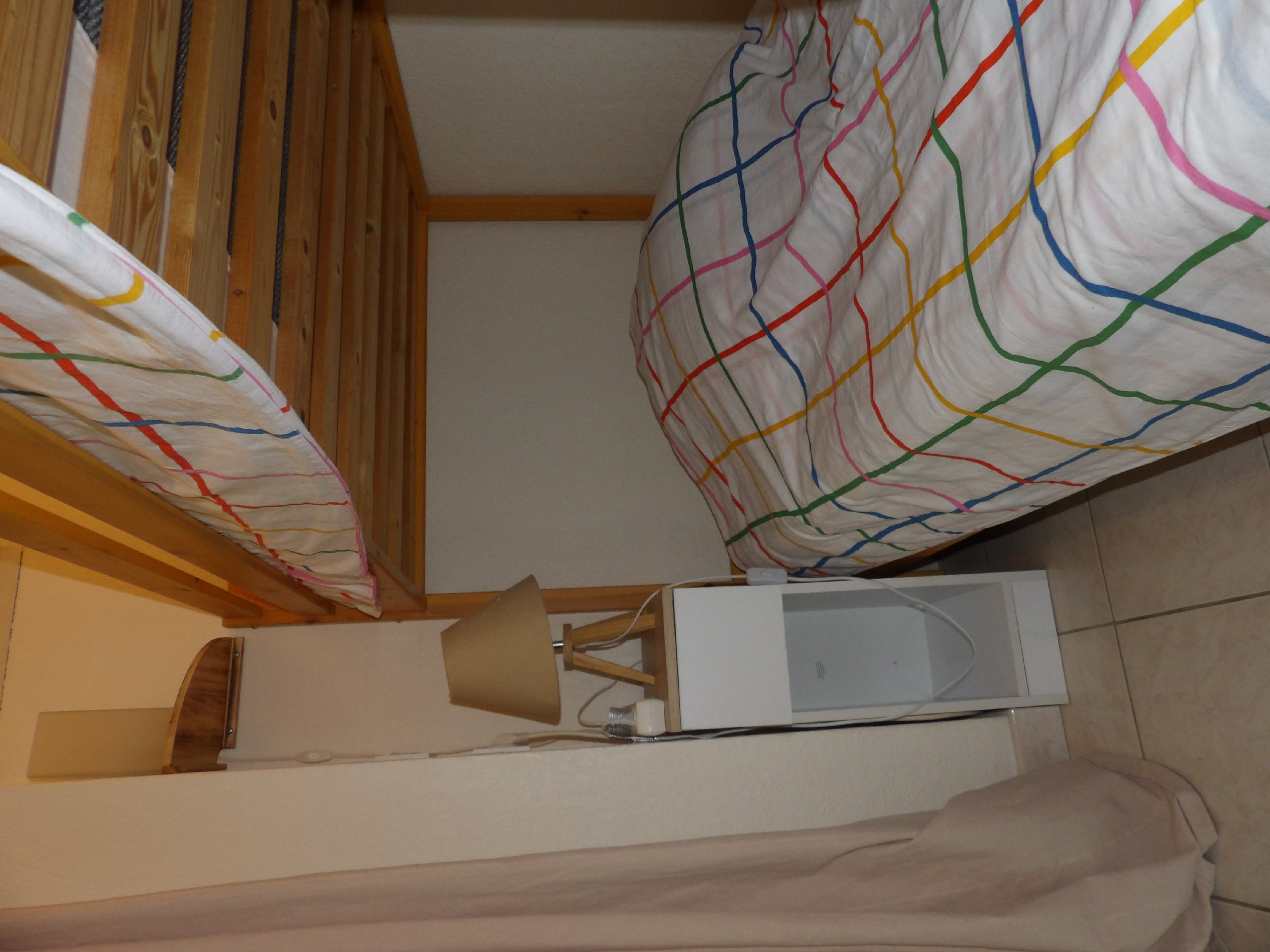 Espace nuit avec lit superposés, table de chevet et lampe, dans un coin cosy