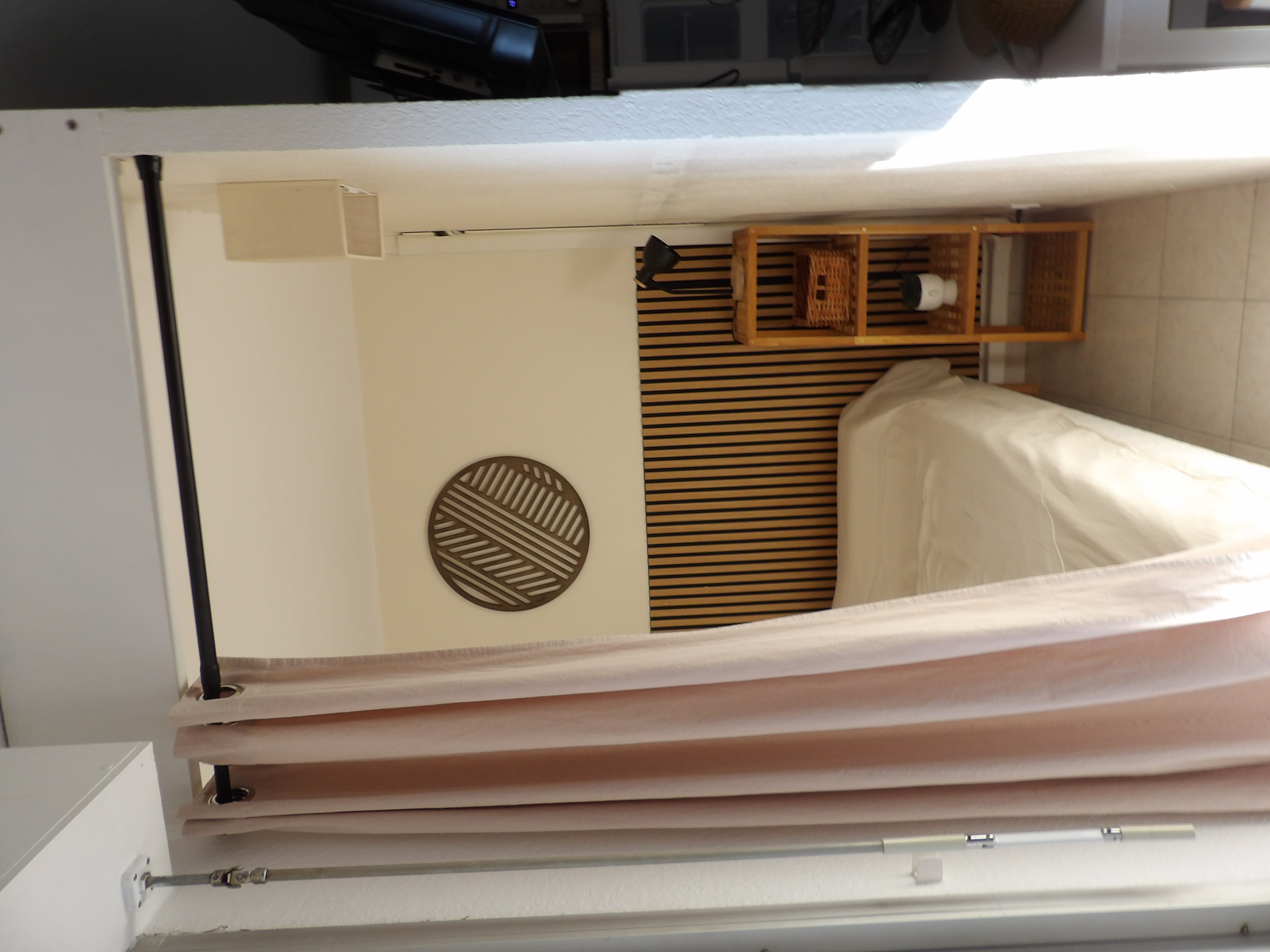 Alcôve chambre ouverte sur le salon par un rideau, avec lit et rangement en bois